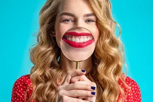 Mujer examinando su sonrisa — candidata a carillas de porcelana