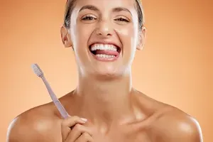 Woman brushing teeth with good oral hygiene habits