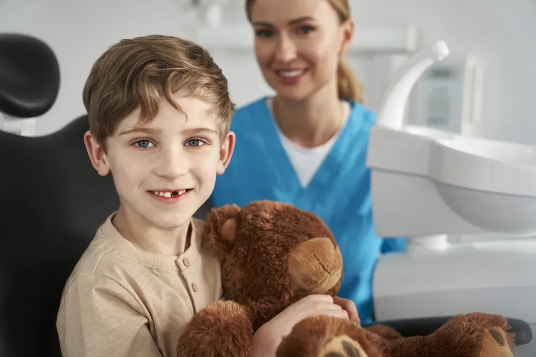 Child at the dental office holding a teddy bear