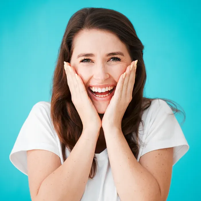 Smiling patient holding her face — placeholder portrait